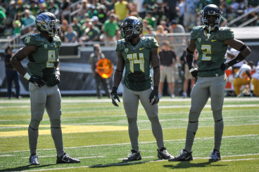 Reggie Daniels (8) with Tyree Robinson (2) and former Duck Ifo Ekpre-Olomu (14)