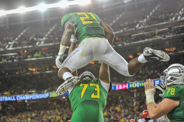 Crosby hoisting star running back Royce Freeman into the air after a touchdown in the Pac-12 championship game.